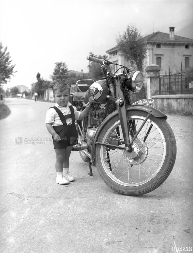 Bambino in posa con motocicletta
